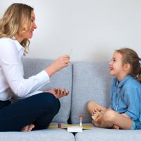 Mother and daughter playing board game